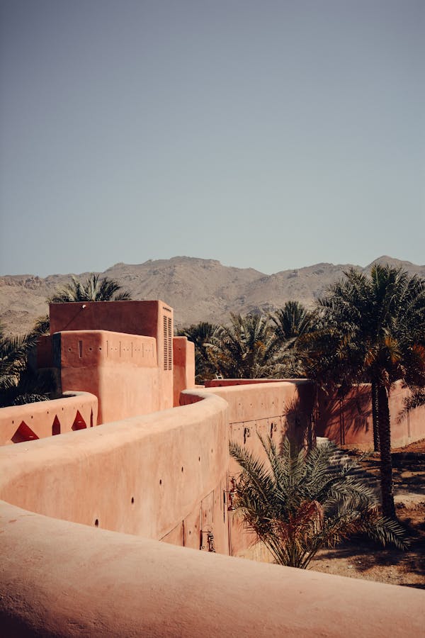 Photo by Reyyan Authentic view of historic architecture surrounded by palm trees in Nizwa, Oman.